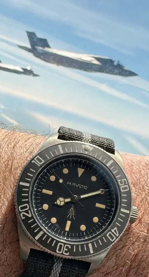 Customer photo of a Havoc watch taken in the air, two jets visible in the background.